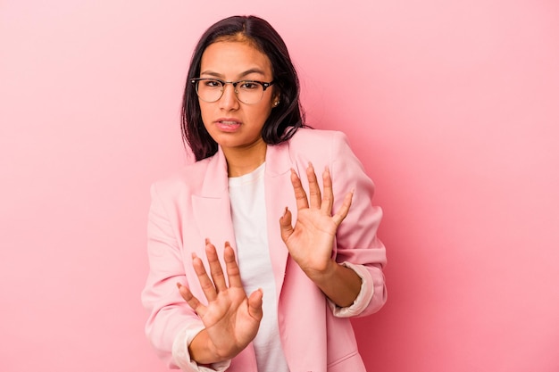 Young latin woman isolated on pink background  rejecting someone showing a gesture of disgust