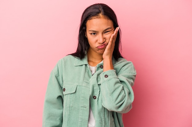 Young latin woman isolated on pink background  who feels sad and pensive, looking at copy space.