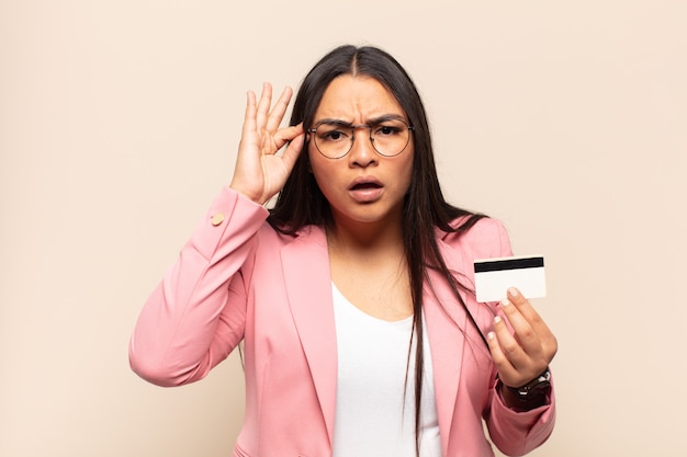 Young latin woman looking surprised, open-mouthed, shocked, realizing a new thought, idea or concept