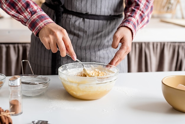 Young latin woman mixing dough cooking at the kitchen