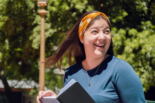 Young latin woman outdoors smiling surprised looking to the side