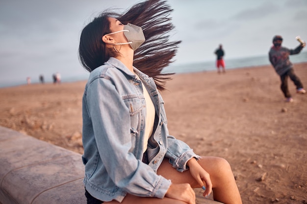 young Latin woman smiles during a beautiful sunset Happy young woman with mask