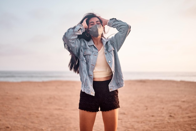 young Latin woman smiles during a beautiful sunset Happy young woman with mask