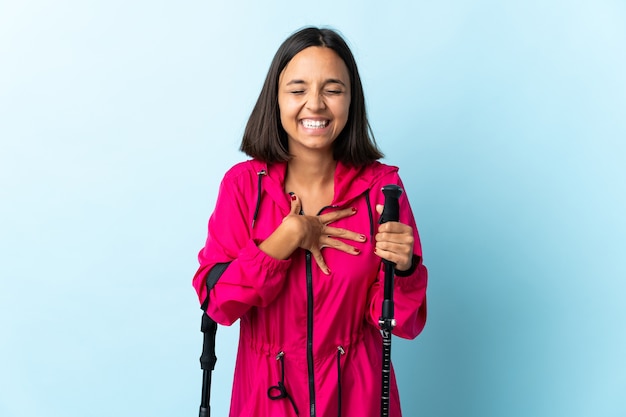 Young latin woman with backpack and trekking poles