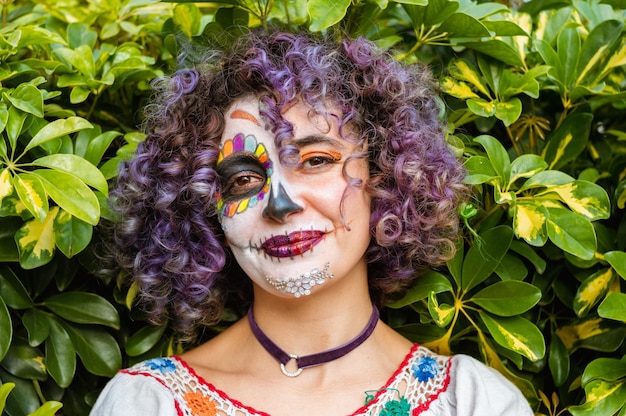 Young latin woman with catrina makeup smiling enjoying day of the dead festivities