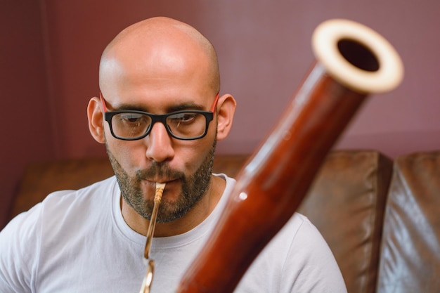 Photo young latino venezuelan musician at home practicing with a bassoon