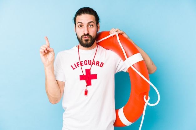 Young lifeguard man holding a rescue float having some great idea