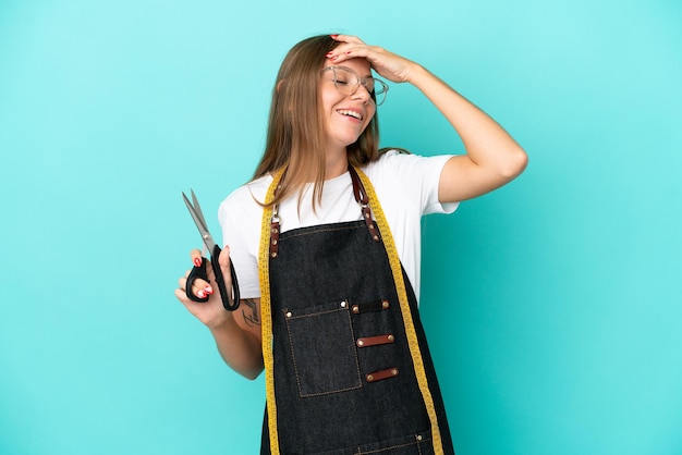 Young Lithuanian seamstress woman isolated on blue background smiling a lot