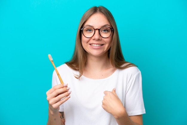 Young Lithuanian woman brushing teeth over isolated background with surprise facial expression