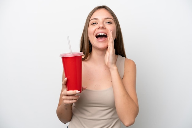 Young Lithuanian woman holding refreshment isolated on white background shouting with mouth wide open