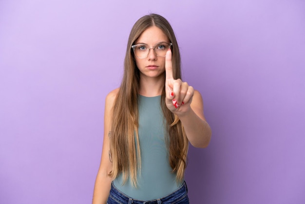 Young Lithuanian woman isolated on purple background counting one with serious expression