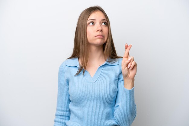 Young Lithuanian woman isolated on white background with fingers crossing and wishing the best