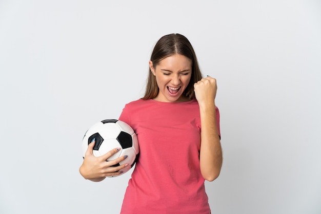 Young Lithuanian woman isolated on white background with soccer ball celebrating a victory