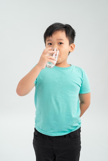 Young little Asian boy taking tablet medicine with a glass of water Healthcare and Medical concept