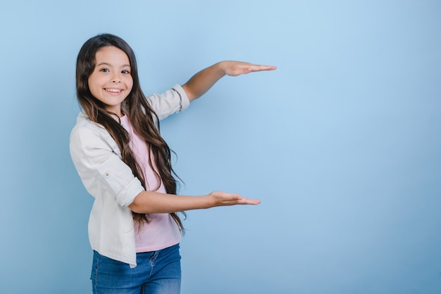 Young little girl holds empty copy space. 