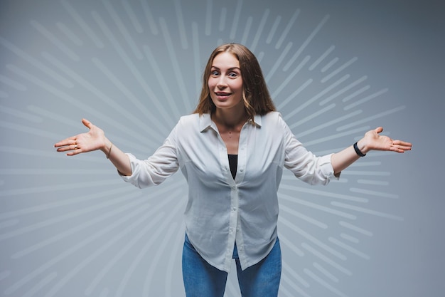 Young longhaired woman in jeans and a white shirt on a plain background Emotions on a woman's face