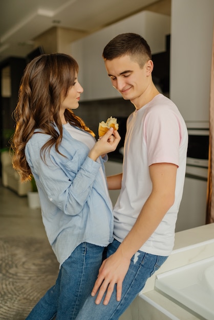 Young loving couple have breakfast in the kitchen. Cute young couple enjoying their breakfast together