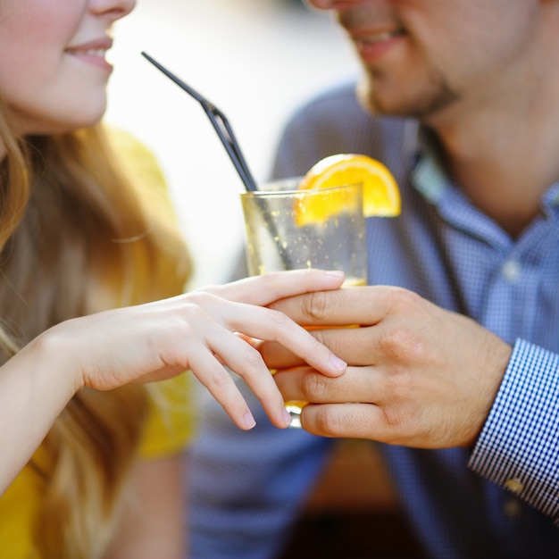 Photo young loving couple holding glass of orange juice