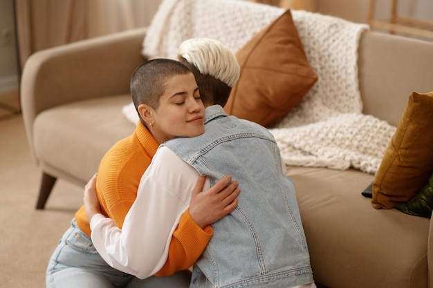 Young loving lesbian woman couple hugging supporting each other reconciling after quarrel. Reunion and resumption of relations concept