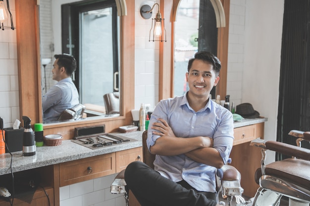 Young male barbershop owner smiling