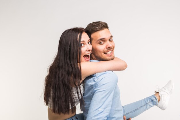 Young male carrying his girlfriend piggyback