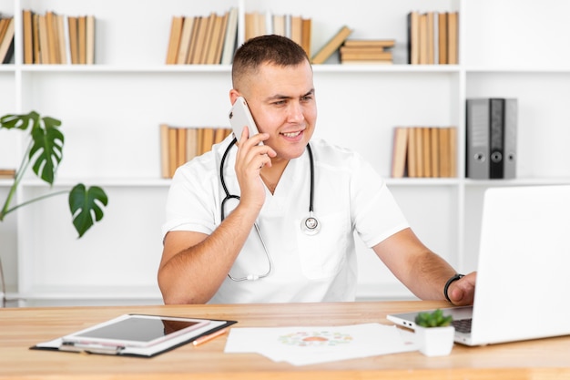 Young male doctor talking on phone