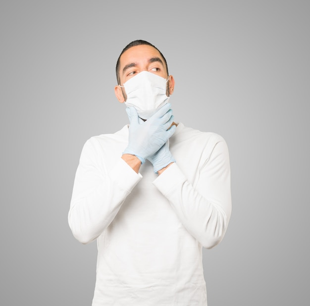 Young male doctor wearing mask and protective gloves