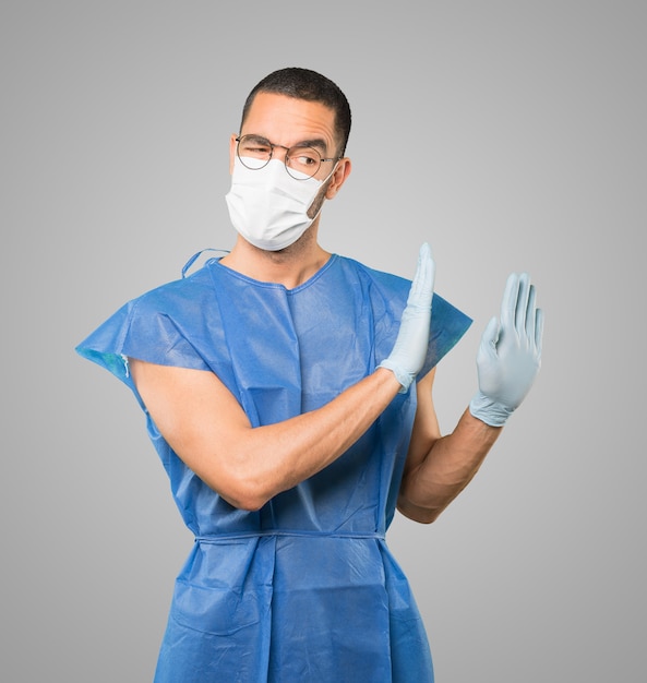 Young male doctor wearing mask and protective gloves