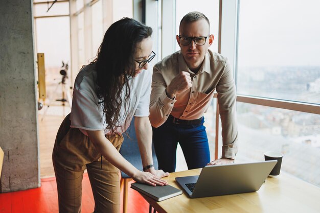 Young male and female colleagues work in a spacious office Successful people are working on a new business project Collective work in the office