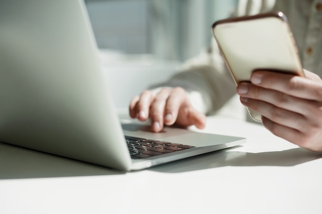 A young male millennial works remotely on a laptop. 