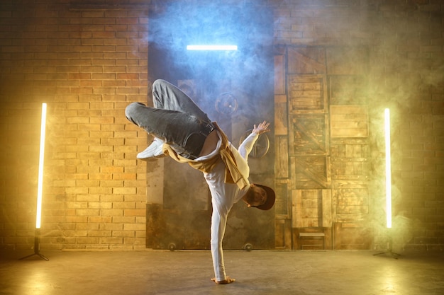 Young male professional dancer b-boying on studio stage