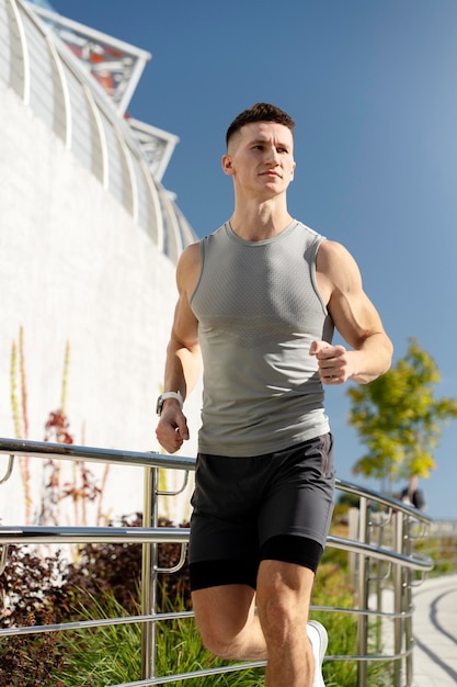 Young male runner jogging on summer street Health care and sport routine concept