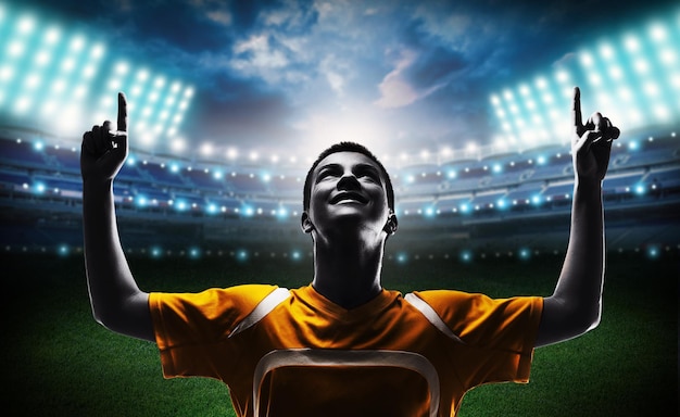 Young Male Soccer Player on blurred sport stadium background