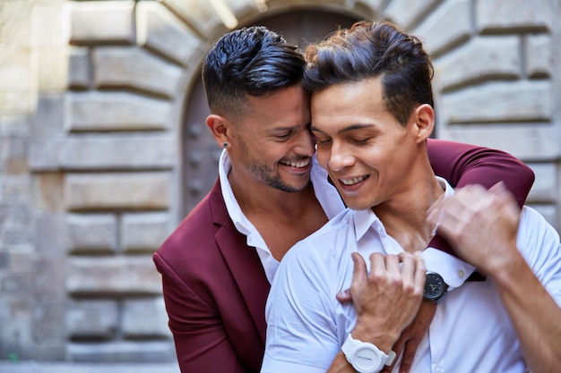 Young males in formal clothes hugging each other and walking on a street