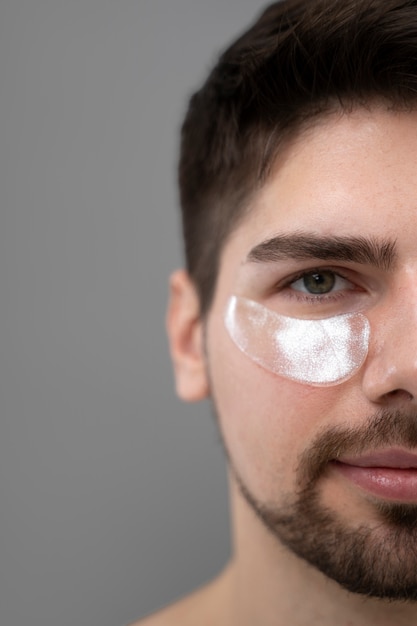 Young man applying anti-dark circle pads