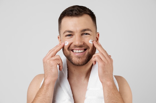 Young man applying his anti aging treatment