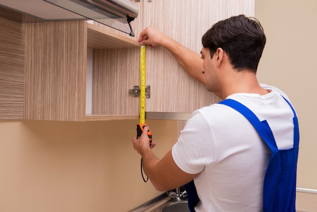 Young man assembling kitchen furniture