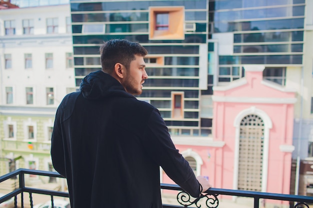 Young man on balcony against buildings