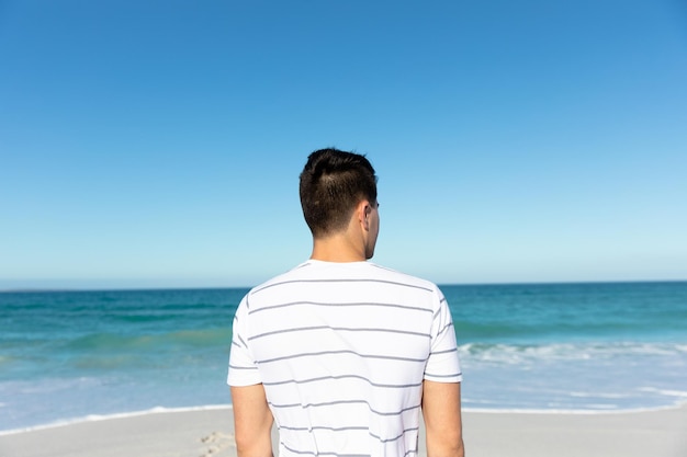 Young man at the beach looking waves