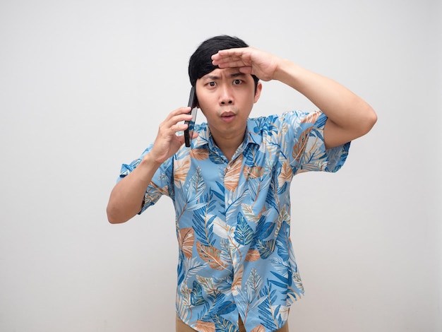 Young man beach shirt hold smartphone feels excited hand at eyebrow isolated