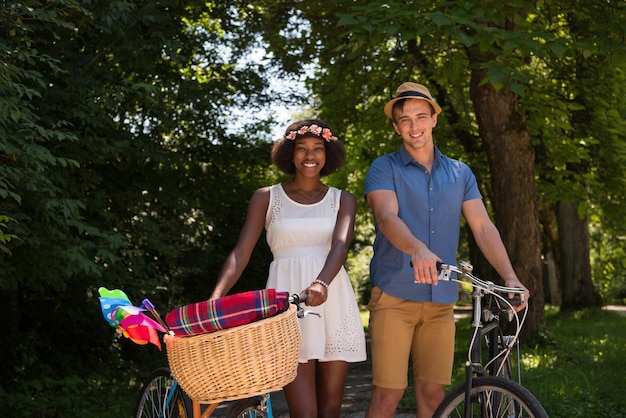 a young man and a beautiful African American girl enjoying a bike ride in nature on a sunny summer day