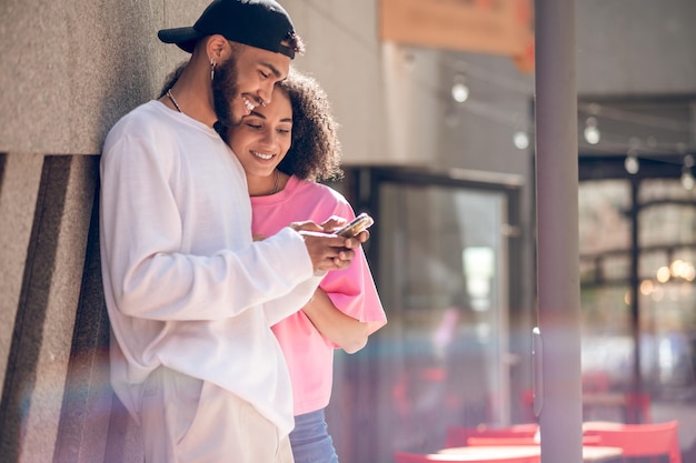 Young man in a black cap and a woman in pink tshirt in the street