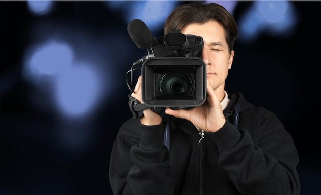 Young man in black clothes holding big video camera