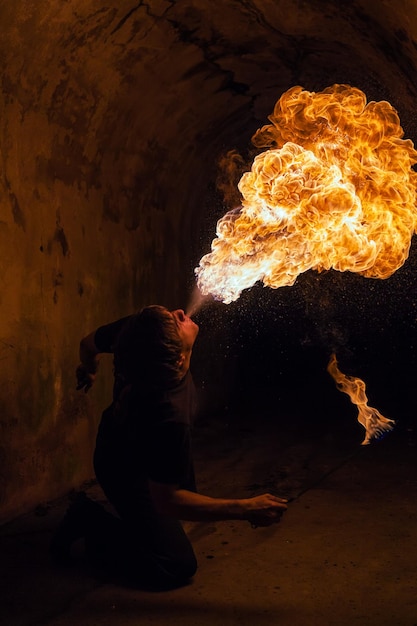 Young man blowing fire from his mouth