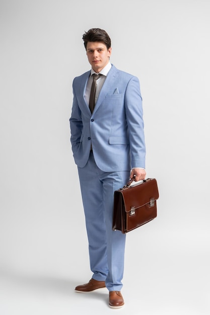 Young man in a blue business suit white shirt and tie with a leather briefcase