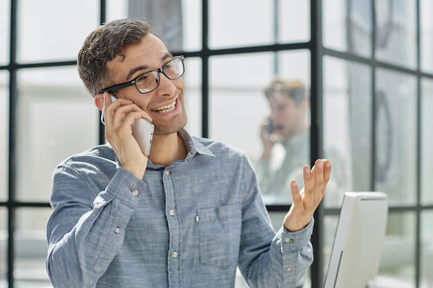 Young man in a blue shirt talking on the phone