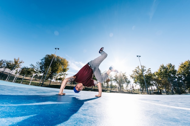 Young man break dancing at basketball court