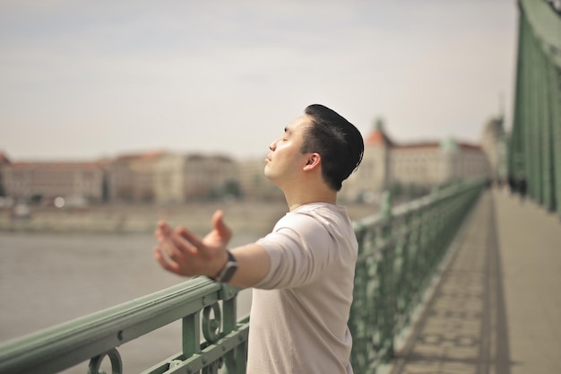 young man breathes air on a bridge