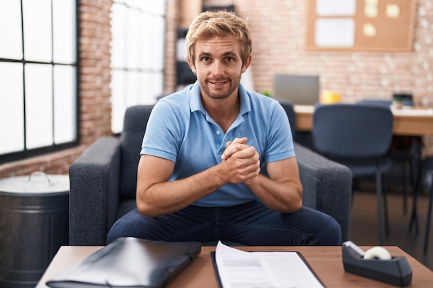 Young man business worker smiling confident sitting on sofa at office