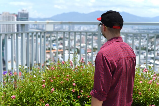 Young man in cap looking left on Vietnamese city Nha Trang